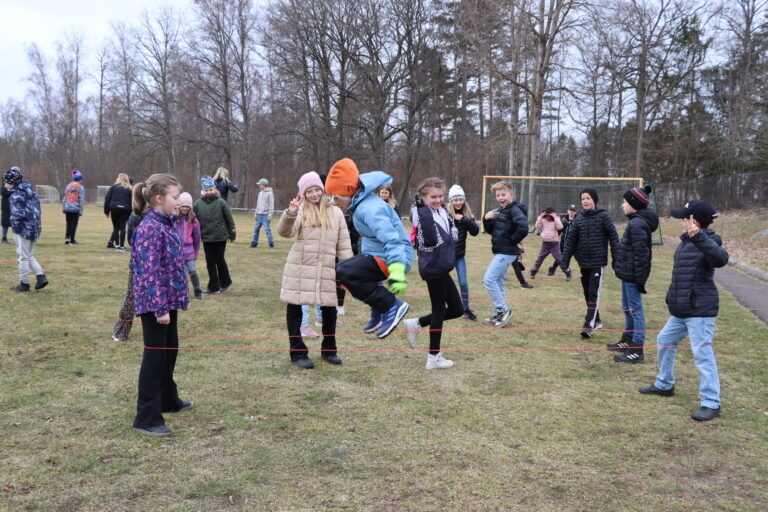 Elever dansar twist utomhus.