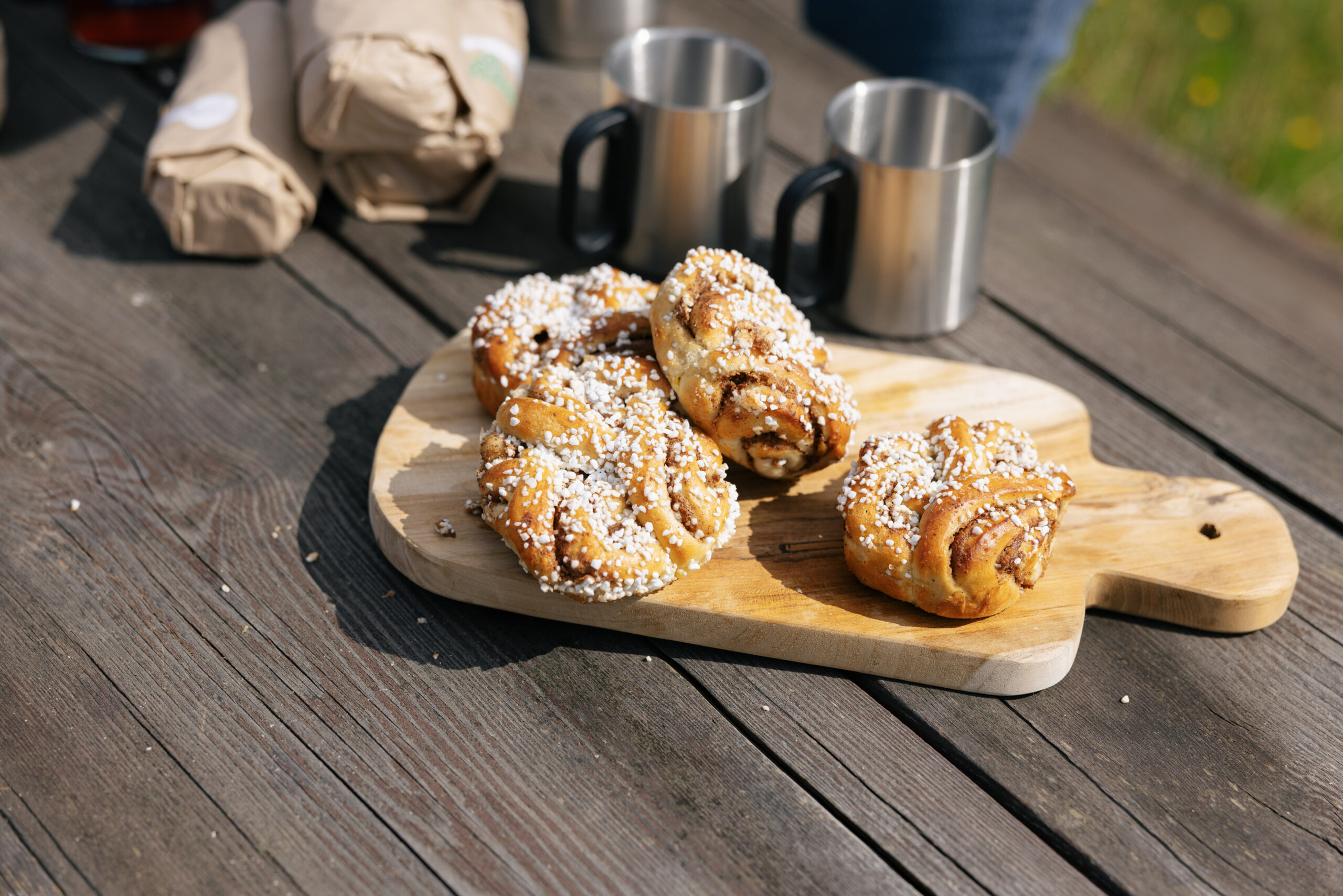 Fika utomhus med kanelbullar, smörgås och kaffe
